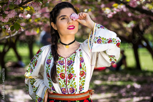 Quadro su tela Beautiful young woman posing in romanian traditional costume in the park