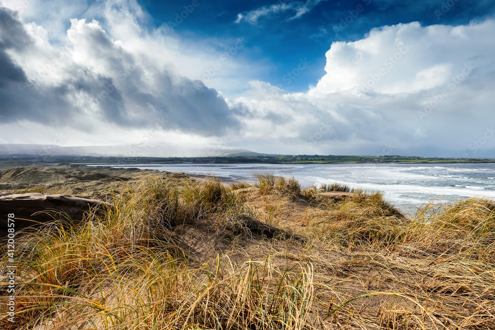 Sand dunes by the ocean. Blue cloudy sky. Nature background. Strandhill beach, Sligo, Ireland. Warm and sunny day