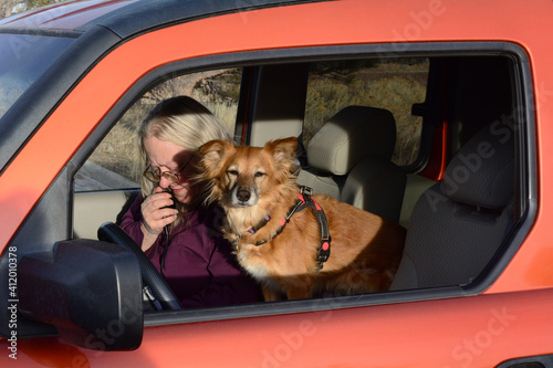 Woman ham amateur radio operator making a voice SSB contact from car with her dog sitting beside her photo