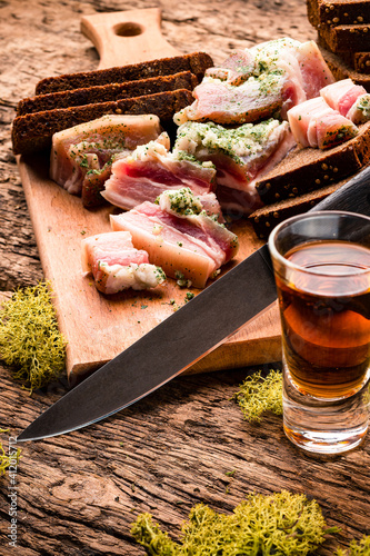 Rustic dinner board with bread, cold meat, hunting knife