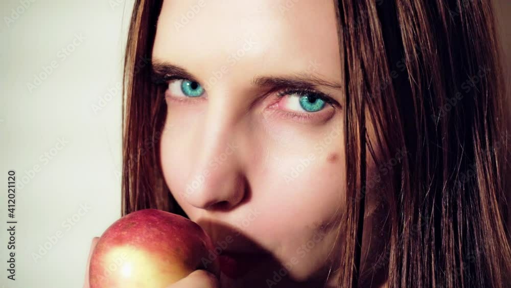 Woman eating apple. Woman seduces eating apple. Close up portrait of a young girl biting and eating red apple and looking at the camera. Apple Temptation.
Woman eating apple. Woman seduces eating apple. Close up portrait of a young girl biting and eating red apple and looking at the camera. Apple Temptation.