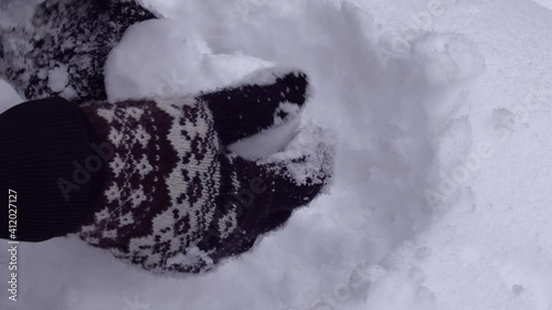 Close up of hands sculpting a heart from snow. Wearing woven gloves with nordic pattern. Snow shaping video. High quality audio recording. ASMR style video and audio. Valentines day message. Love sign