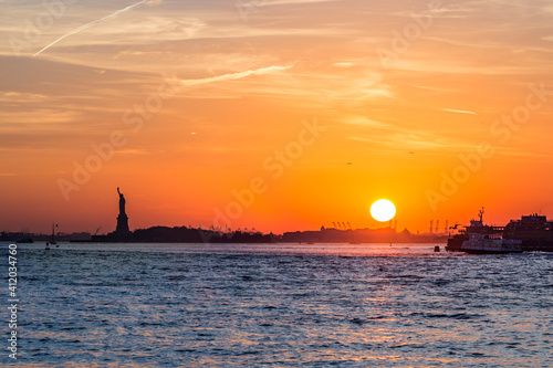 panoramic view to New York in sunset with statue of liberty at horizon