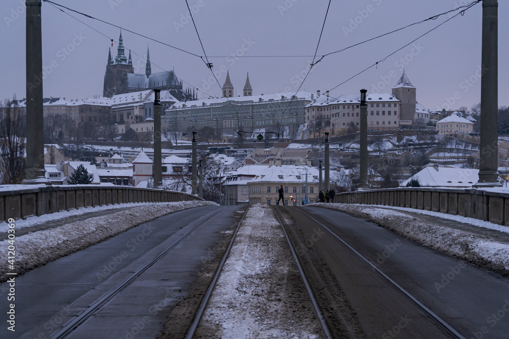 snowy road in the city of Prague and behind the Prague Castle and snowy sidewalks