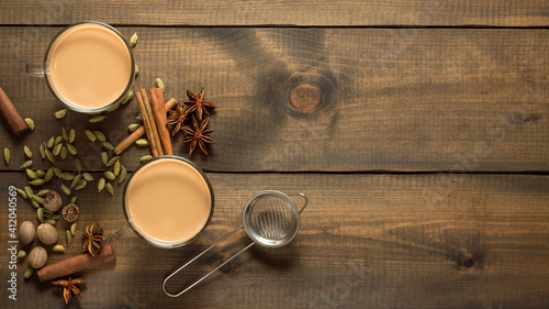 Canvas Print Two mugs with masala tea stand on a wooden table with spices
