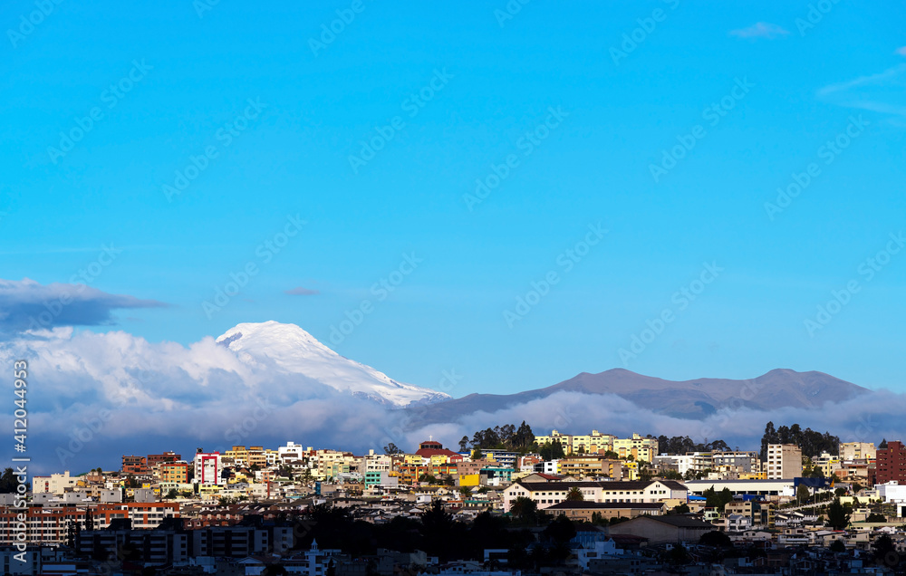 Quito aerial skyline at sunset with Cayambe volcano and copy space, Ecuador.