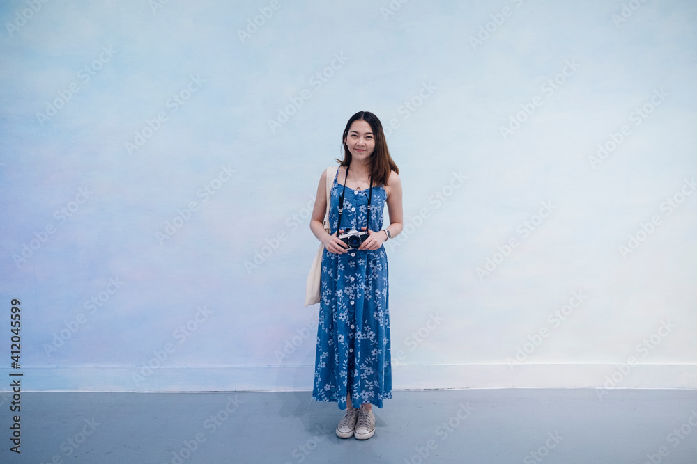 Portrait of young asian thai woman in blue dress with camera isolate over white background. Portrait of young asian thai woman in blue dress with camera isolate over white background.