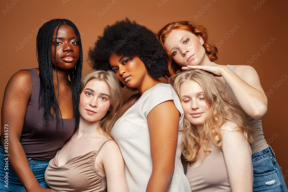 Obraz premium young pretty caucasian, afro, scandinavian woman posing cheerful together on brown background, lifestyle diverse nationality people concept