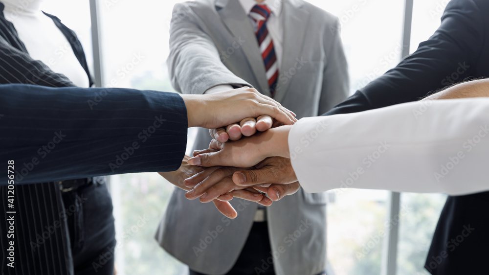Hands of businesspeople stacked together in the symbol of unity and trust in same team.