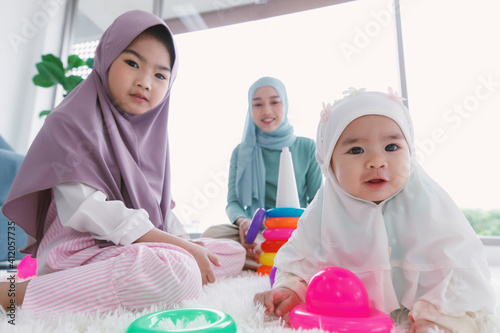 Canvas Print Asian Muslim family, mother and two daughters, one kid and one infant wearing th