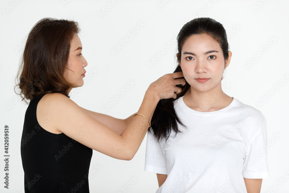 Behind the scene working in a portrait studio, young and cute stylish helping the beautiful model to arrange hair and cloth for a perfect scene Behind the scene working in a portrait studio, young and cute stylish helping the beautiful model to arrange hair and cloth for a perfect scene