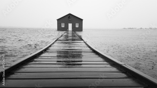 Blue boathouse during rain and high tide