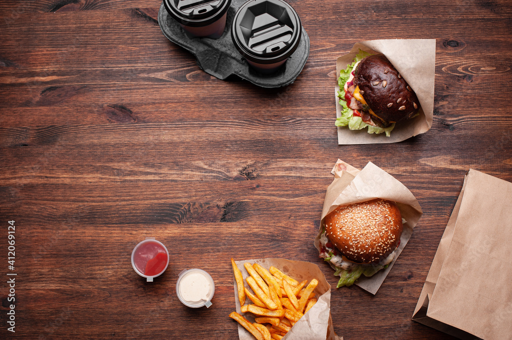 Burgers and fries top view on wood