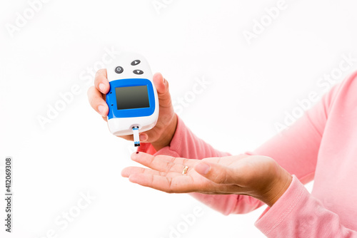 Hands woman measuring glucose test level check with blood on finger by glucometer she monitor and control high blood sugar diabetes and glycemic health care concept isolated on white background