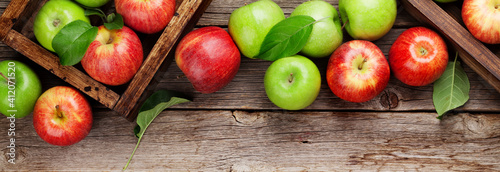 Green and red apples in wooden boxes