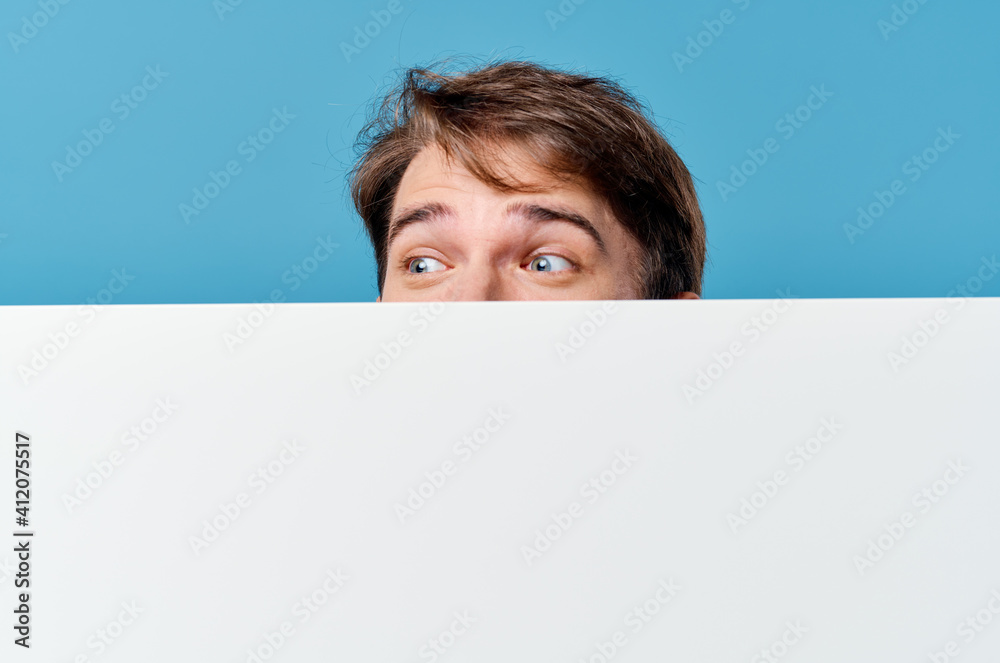 man peeking out from behind banner cropped view advertisement copy space blue background man peeking out from behind banner cropped view advertisement copy space blue background