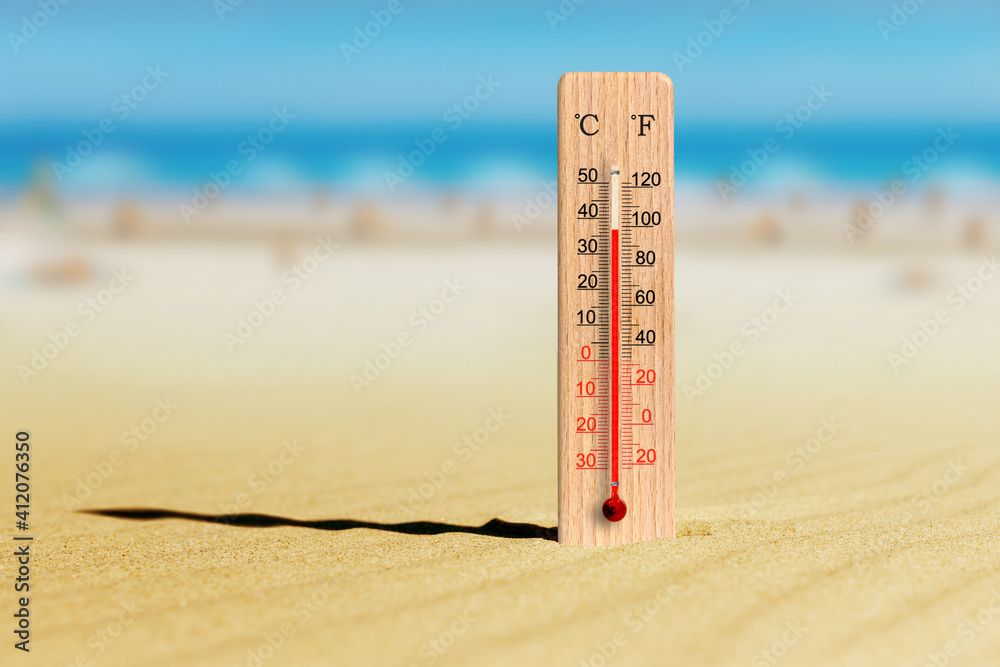 Sea coast at hot summer day. Wooden thermometer in the sand. Ambient temperature plus 37 degrees celsius - obrazy, fototapety, plakaty 