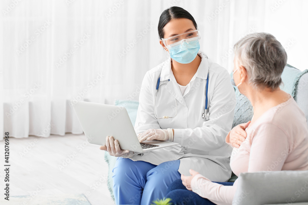 Obraz premium Doctor visiting senior woman at home