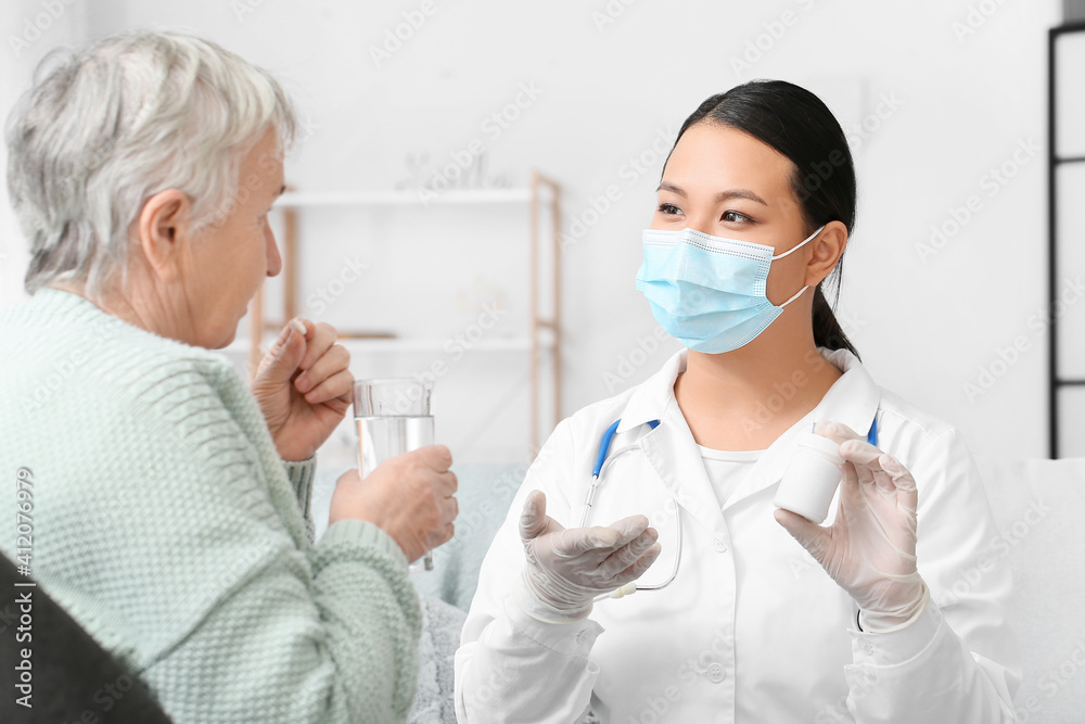 Doctor giving remedy to senior woman at home Doctor giving remedy to senior woman at home