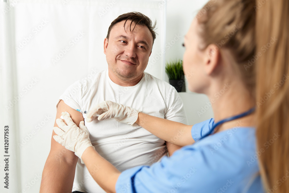 woman doctor injections in the shoulder of a man patient health care covid vaccination woman doctor injections in the shoulder of a man patient health care covid vaccination