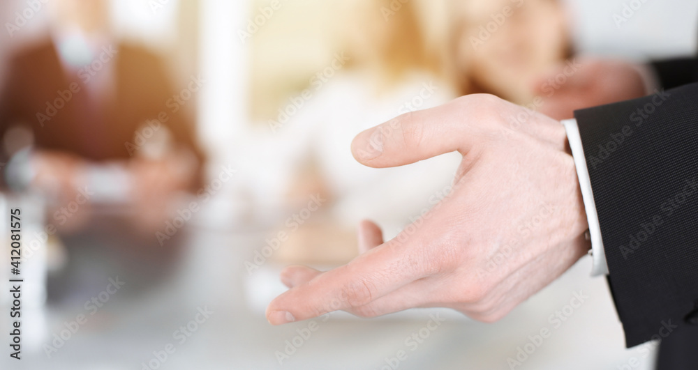 Business presentation. Businessman giving speech to colleagues and partners at corporate meeting or conference, close-up of speaker hands