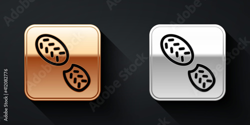 Gold and silver Human footprints shoes icon isolated on black background. Shoes sole. Long shadow style. Vector.