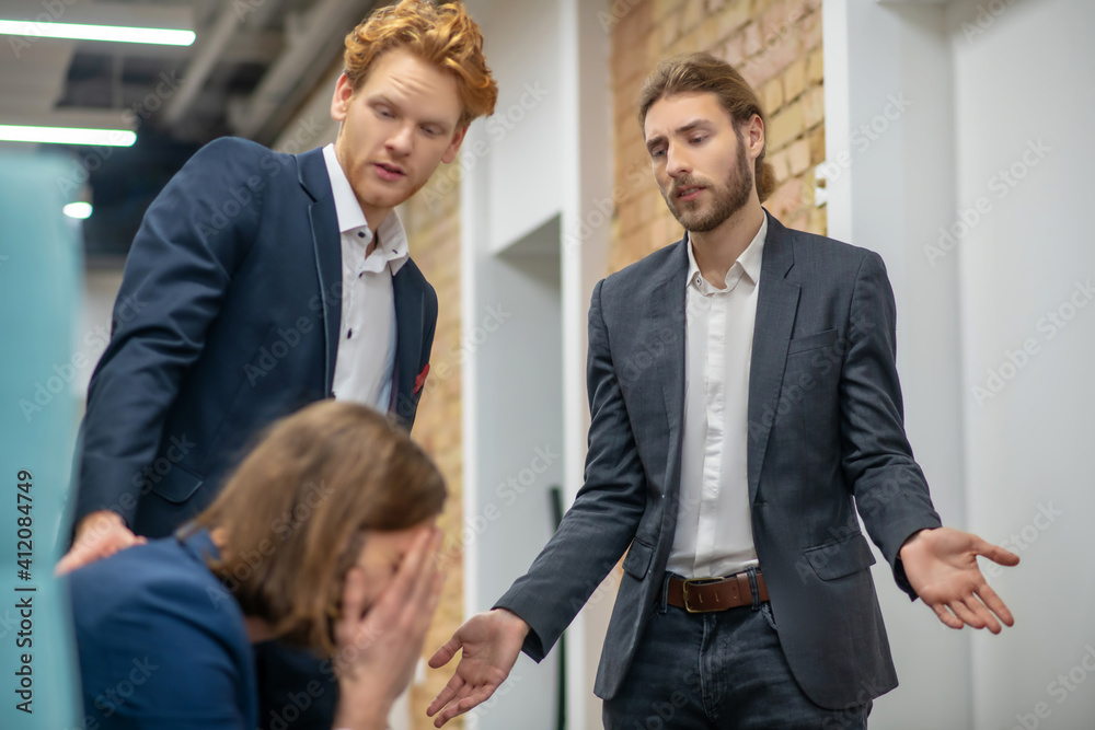 Unhappy man and two supportive colleagues