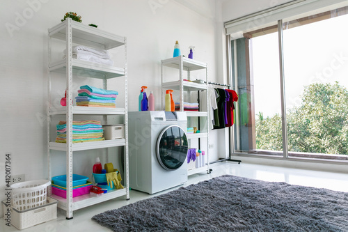 Laundry room interior with washing machine against white wall. photo