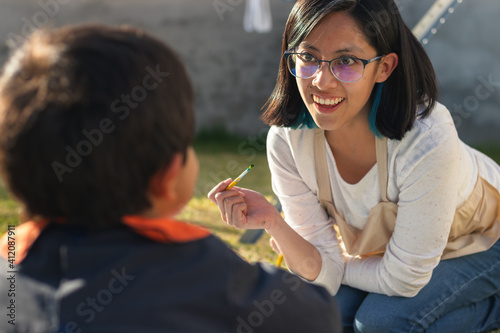 A young woman smiling and painting in the yard