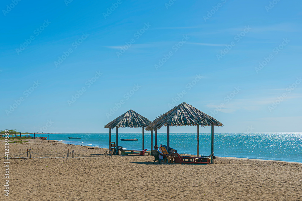 Fototapeta premium Couple of huts on a tropical beach under a bright sun