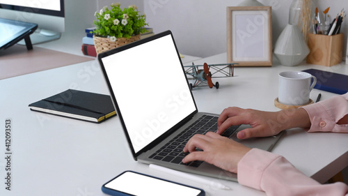 Cropped shot of businesswoman sitting at office desk and working with laptop computer.
