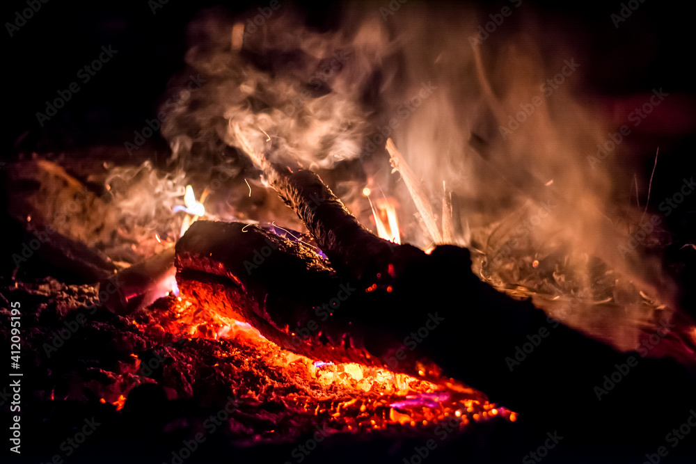Close-up of a log burning in a fire with smoke