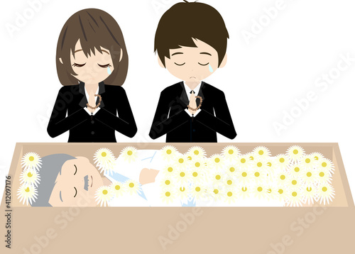 故人にお花を添えて祈る遺族