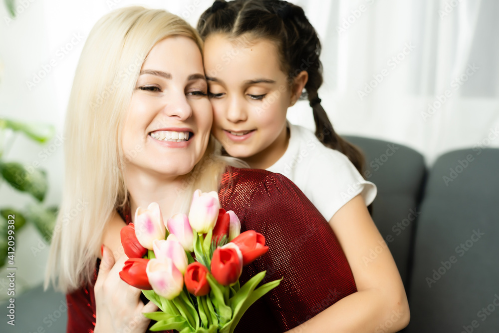 Trendy attractive cheerful mother and daughter enjoying holiday together having big flawless seasonal colorful bouquet of tulips, comfort pleasure joy enjoyment concept on grey background