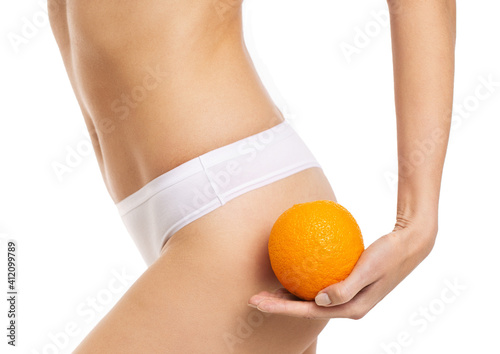 beautiful slim female waist on a white background with orange