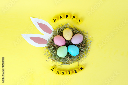 colored eggs in nest easr bunny and the letter of the cubes happy Easter
