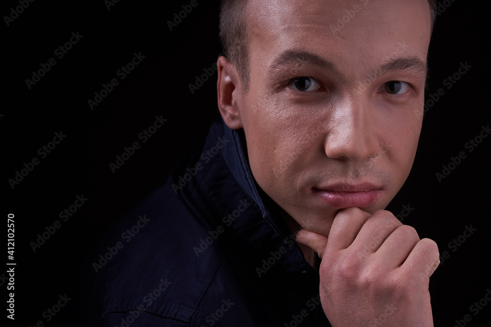 Close up portrait of a beautiful confident young man on a black isolated background in a Studio with copy space, he looks at the camera Close up portrait of a beautiful confident young man on a black isolated background in a Studio with copy space, he looks at the camera