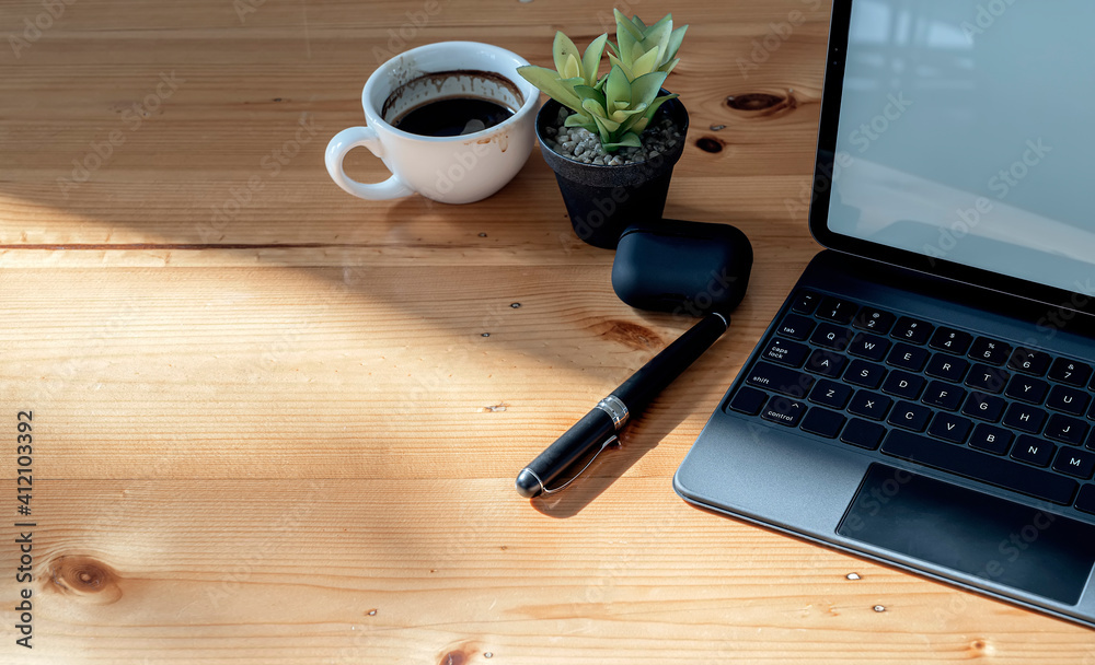 Top view tablet keyboard, cup of coffee, pen and houseplant on wooden top table with copy space. Top view tablet keyboard, cup of coffee, pen and houseplant on wooden top table with copy space.