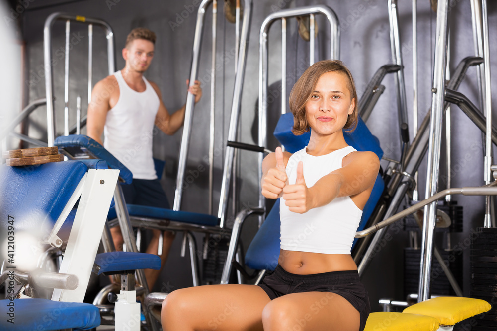 Fototapeta premium Young woman taking pause between exercising in gym indoors