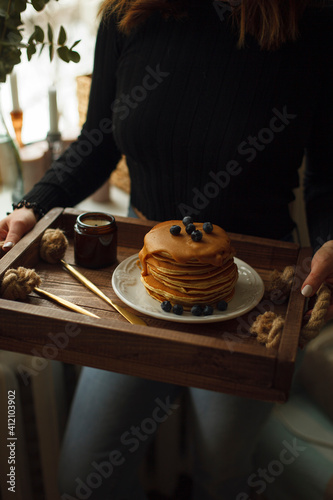 woman holding pancakes with blueberries in her hands