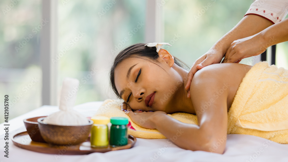 Foto de beautiful Asian woman enjoy getting an oil massage happily in a  spa. Relaxing and healing with Thai massage and aroma oil. Body care and  treatment, alternative medicine concept do Stock