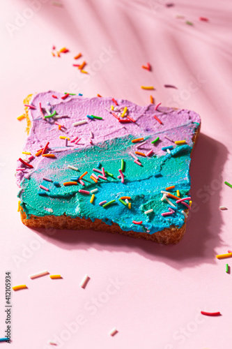 Unicorn toasted bread with colored cream cheese on pink background.