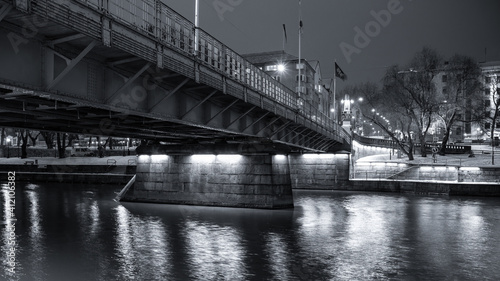 Black and white photo of a steel bridge over a river in Turku, Finland. © Finmiki
