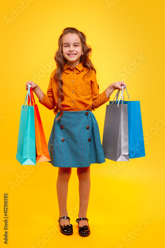 Excited stylish girl carrying shopping bags