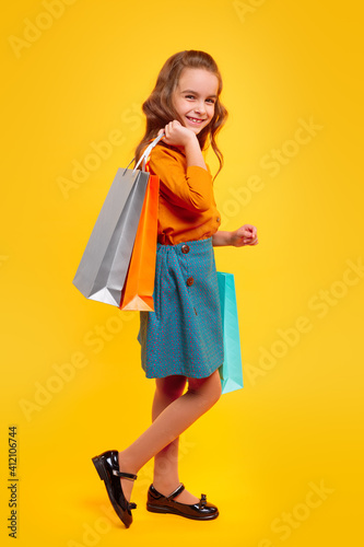 Happy schoolgirl in casual outfit enjoying shopping