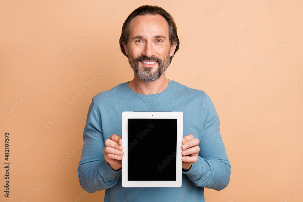 Photo portrait of businessman showing tablet touchscreen with copyspace isolated on pastel beige color background