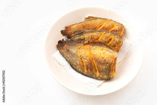 Deep-fried fishes or Snakeskin gourami fish in the round disk on white background with clipping path. The fish is called Pla Salid or Slid in Thailand language.