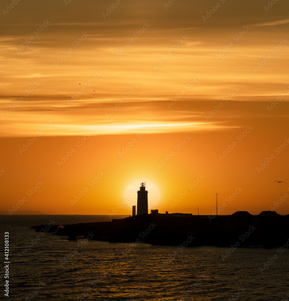 Lighthouse at sunset with sun in the background