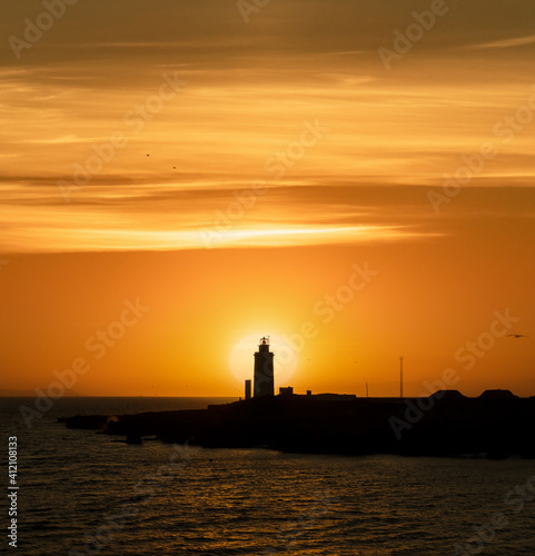 Lighthouse at sunset with sun in the background