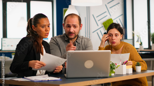 Wallpaper Mural Colleagues sitting at desk, working with laptop computer, showing first project results to confident boss team leader explaining financial strategy. Diverse business partners developing startup idea. Torontodigital.ca